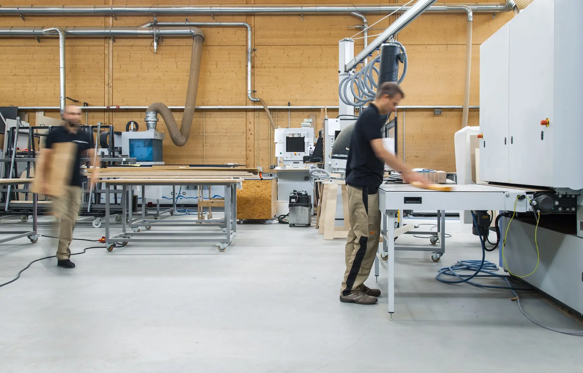 woman in black shirt and gray pants standing near white table